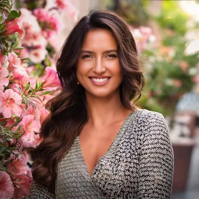 Portrait Of A Smiling Woman Beside Pink Flowers