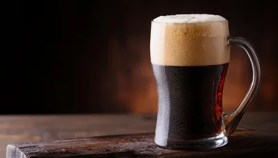 Cold Glass Of Dark Stout Beer On Wooden Table