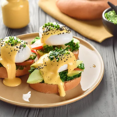 Gourmet Eggs Benedict With Avocado And Greens