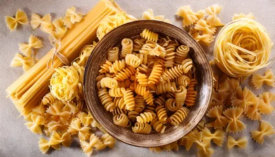 Assorted Dry Pasta Varieties On A Textured Surface
