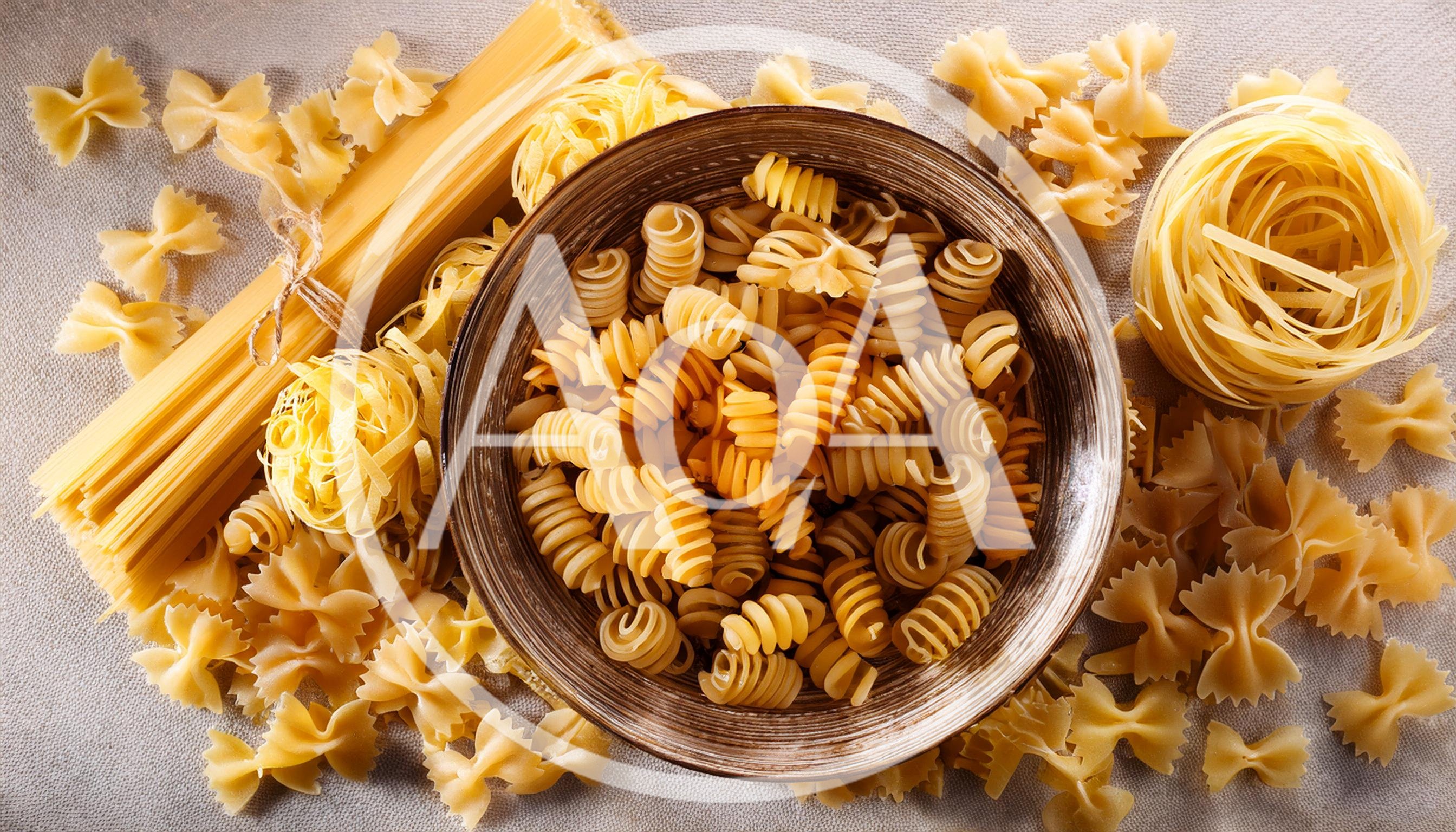 Assorted Dry Pasta Varieties On A Textured Surface