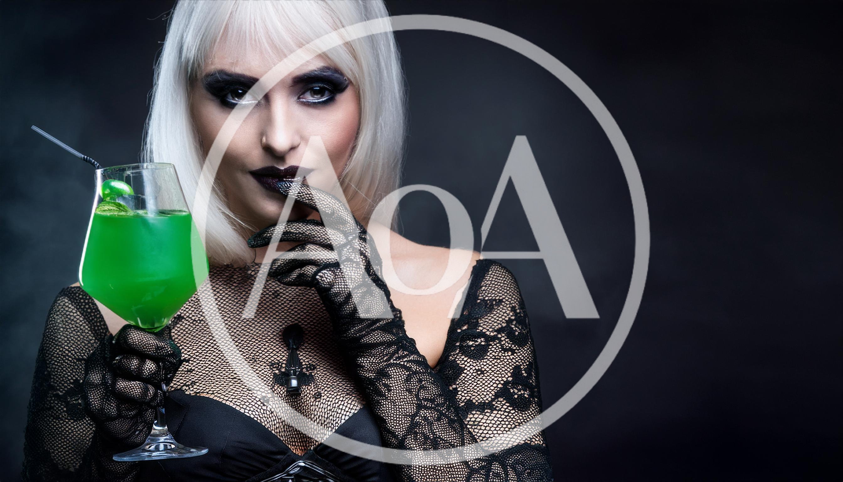 Gothic Woman Holding A Green Cocktail In Lace Gloves
