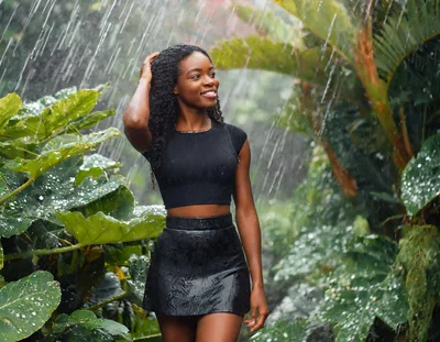 Young Woman Enjoying Tropical Rain in Lush Garden