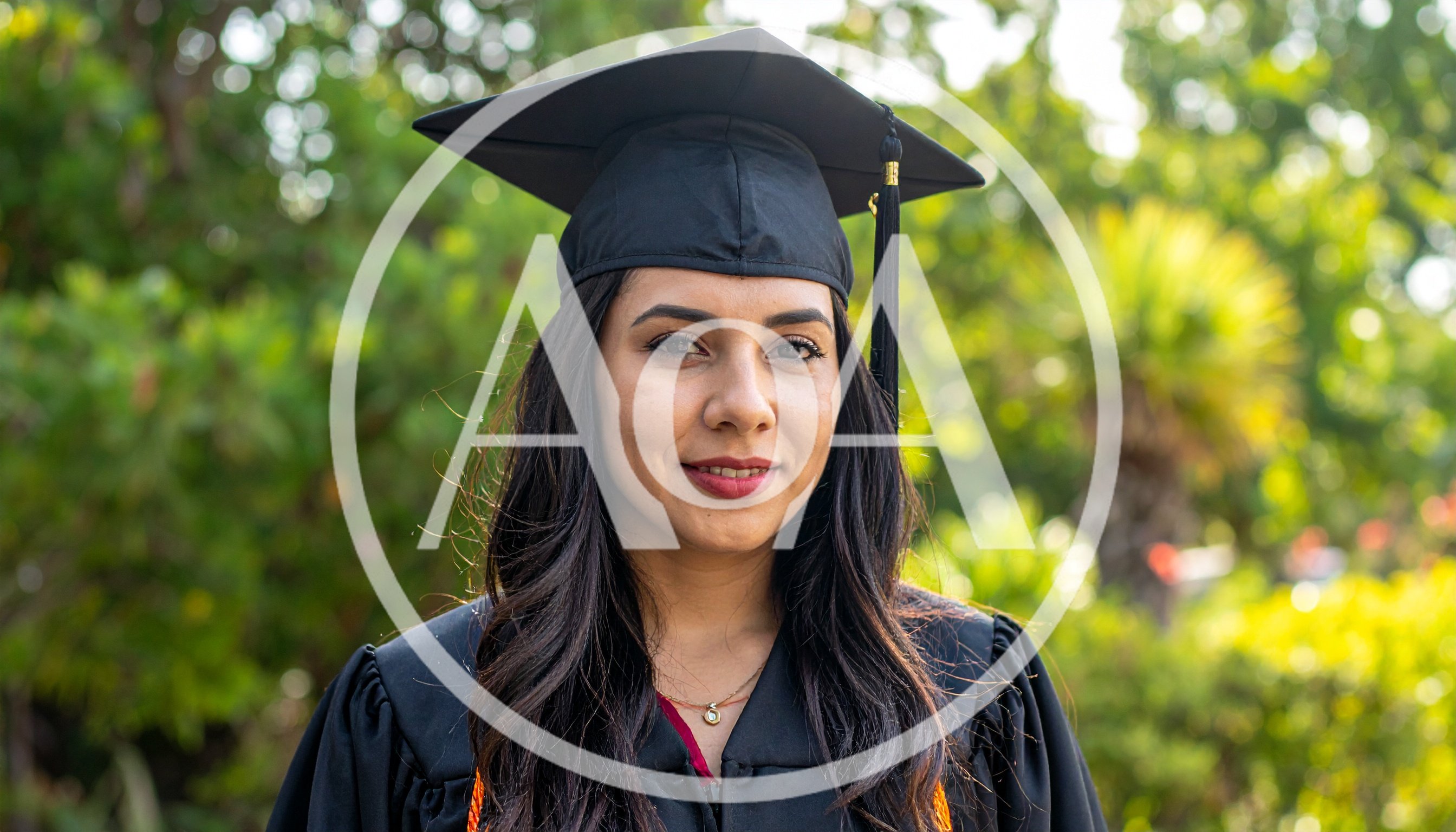 Young Woman Wearing Graduation Cap and Gown Outdoors