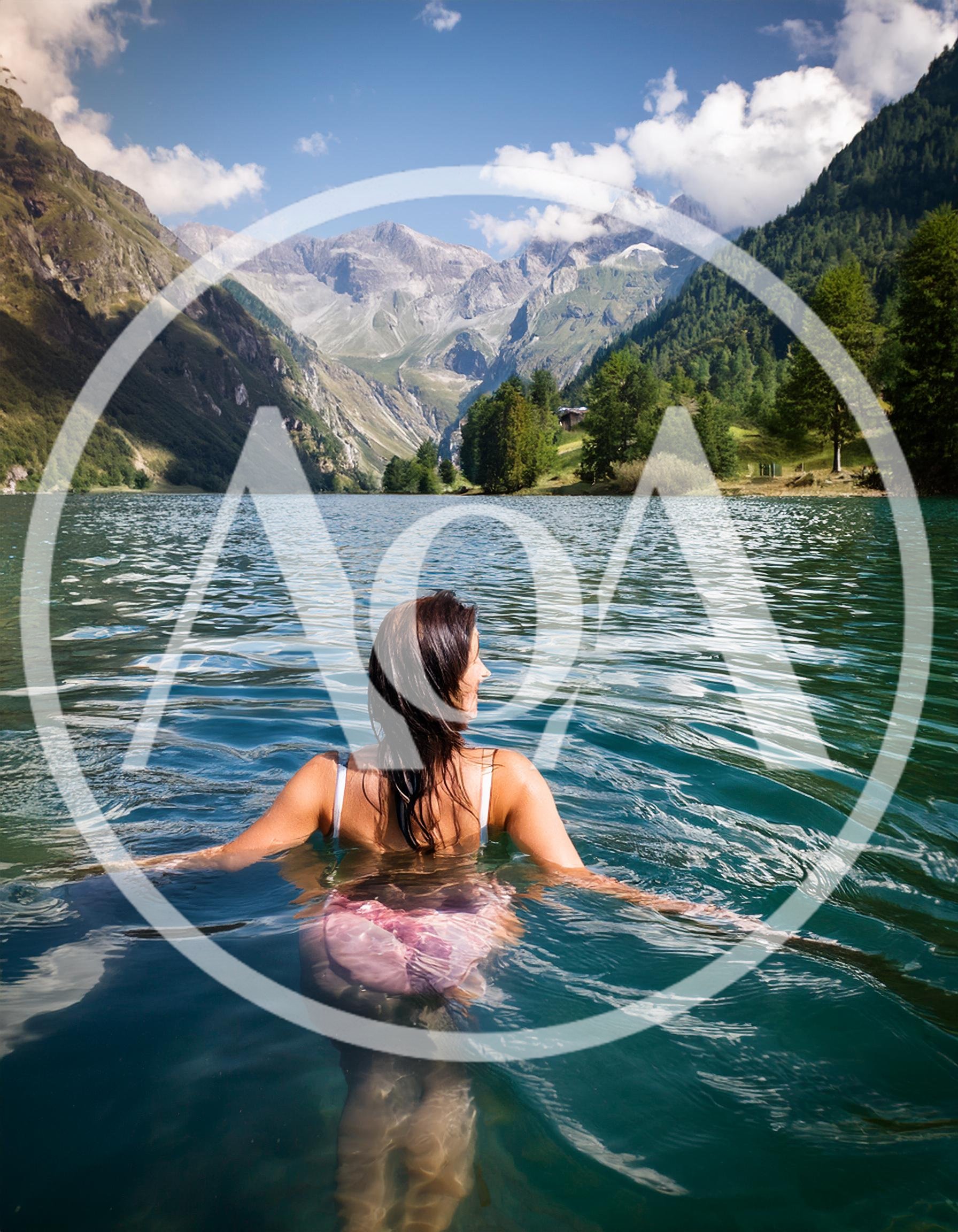 Woman Swimming In A Scenic Alpine Lake