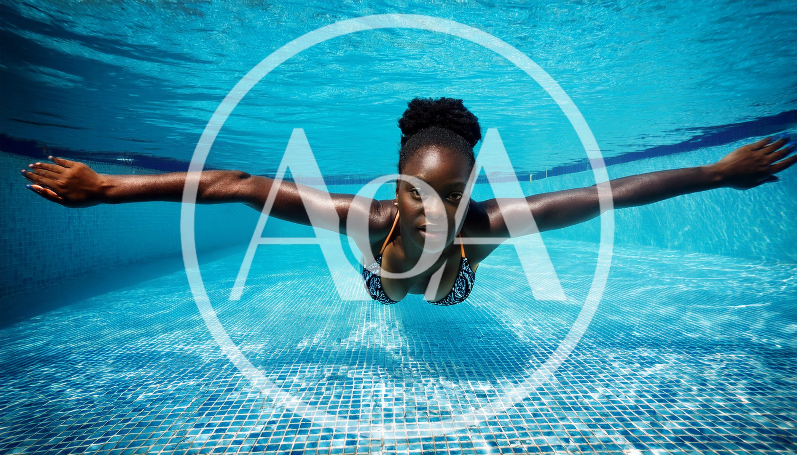 Young Black Woman Swimming Underwater in a Pool