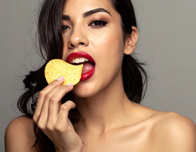 Beautiful Woman Eating A Crispy Potato Chip