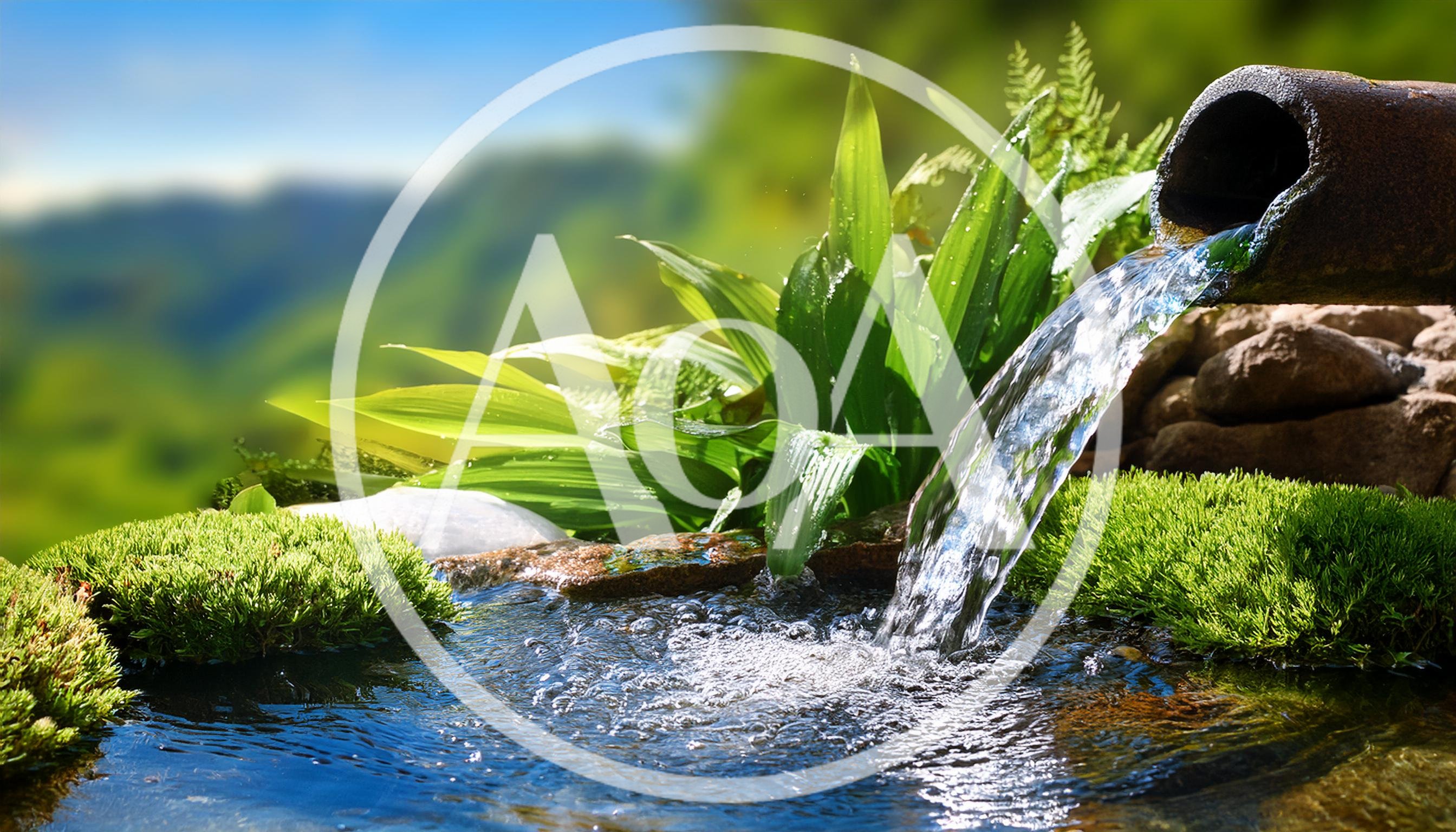 Water Flowing From A Pipe Into A Garden Pond