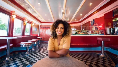 Young Woman Smiling In A Retro American Diner
