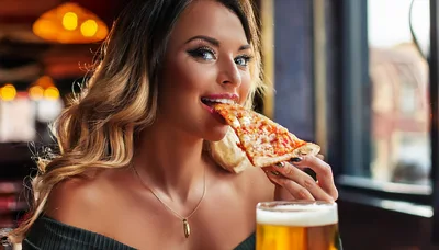 Young Woman Eating Pizza Slice In A Restaurant