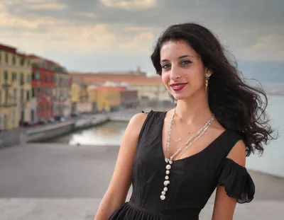 Young Woman Posing In A Black Dress By The River