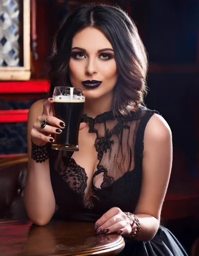 Elegant Woman Holding A Glass Of Dark Beer