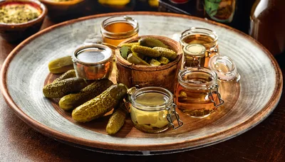 Assorted Pickles and Jars of Brine on Wooden Platter
