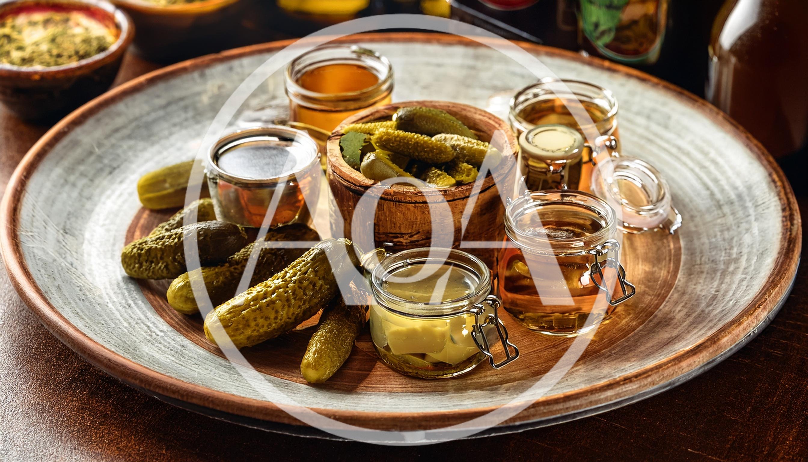 Assorted Pickles and Jars of Brine on Wooden Platter