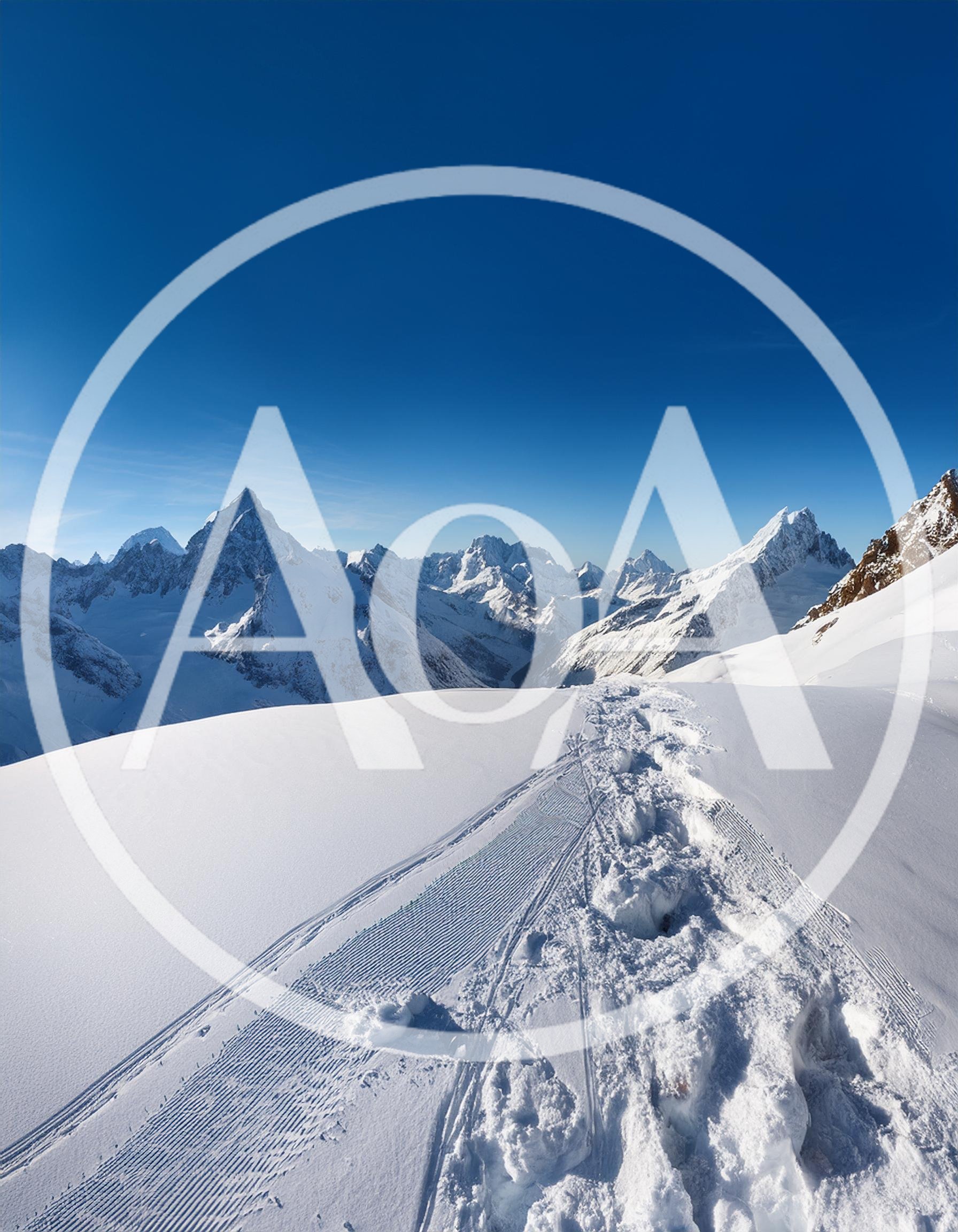 Snowy Mountain Peak With Footprints And Ski Tracks