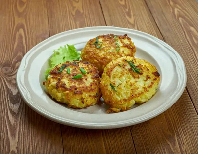 Three Golden Fried Potato Pancakes On A Plate