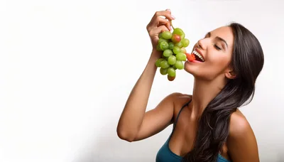 Young Woman Eating Fresh Grapes And Strawberry