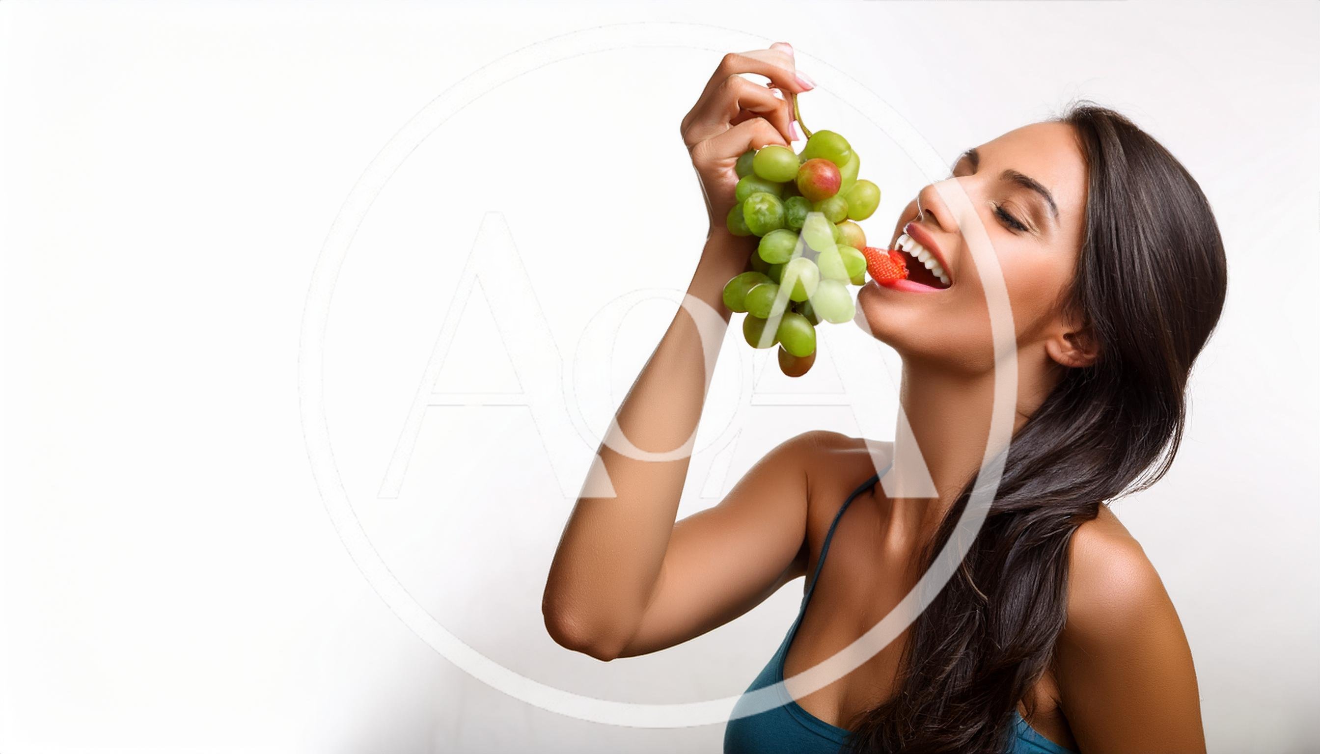 Young Woman Eating Fresh Grapes And Strawberry