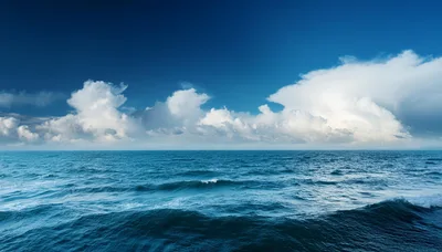 Expansive Blue Ocean Waves Under A Cloudy Sky