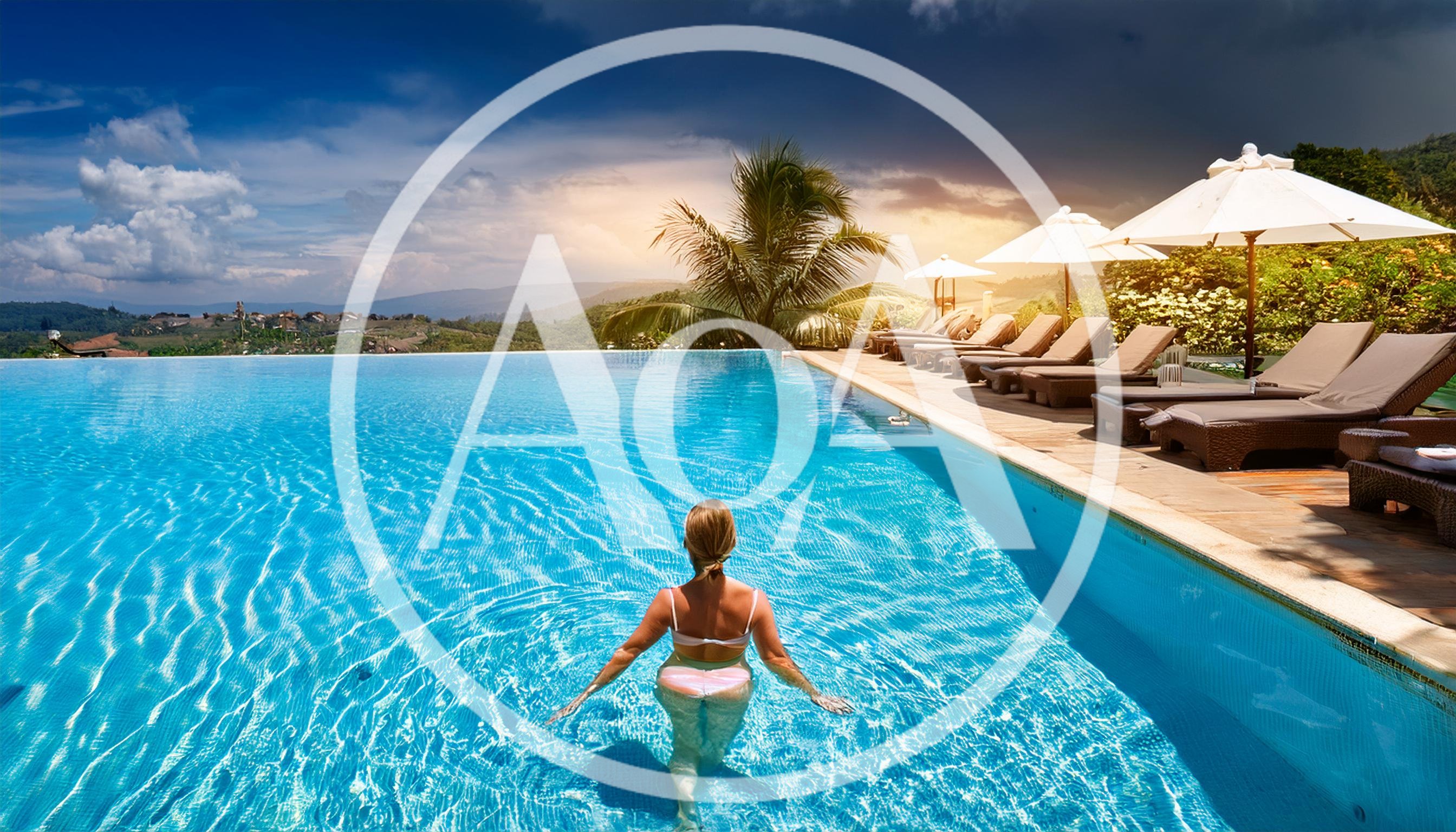 Woman Relaxing In Infinity Pool At Luxury Resort