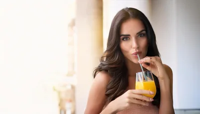 Beautiful Woman Drinking Orange Juice With A Straw