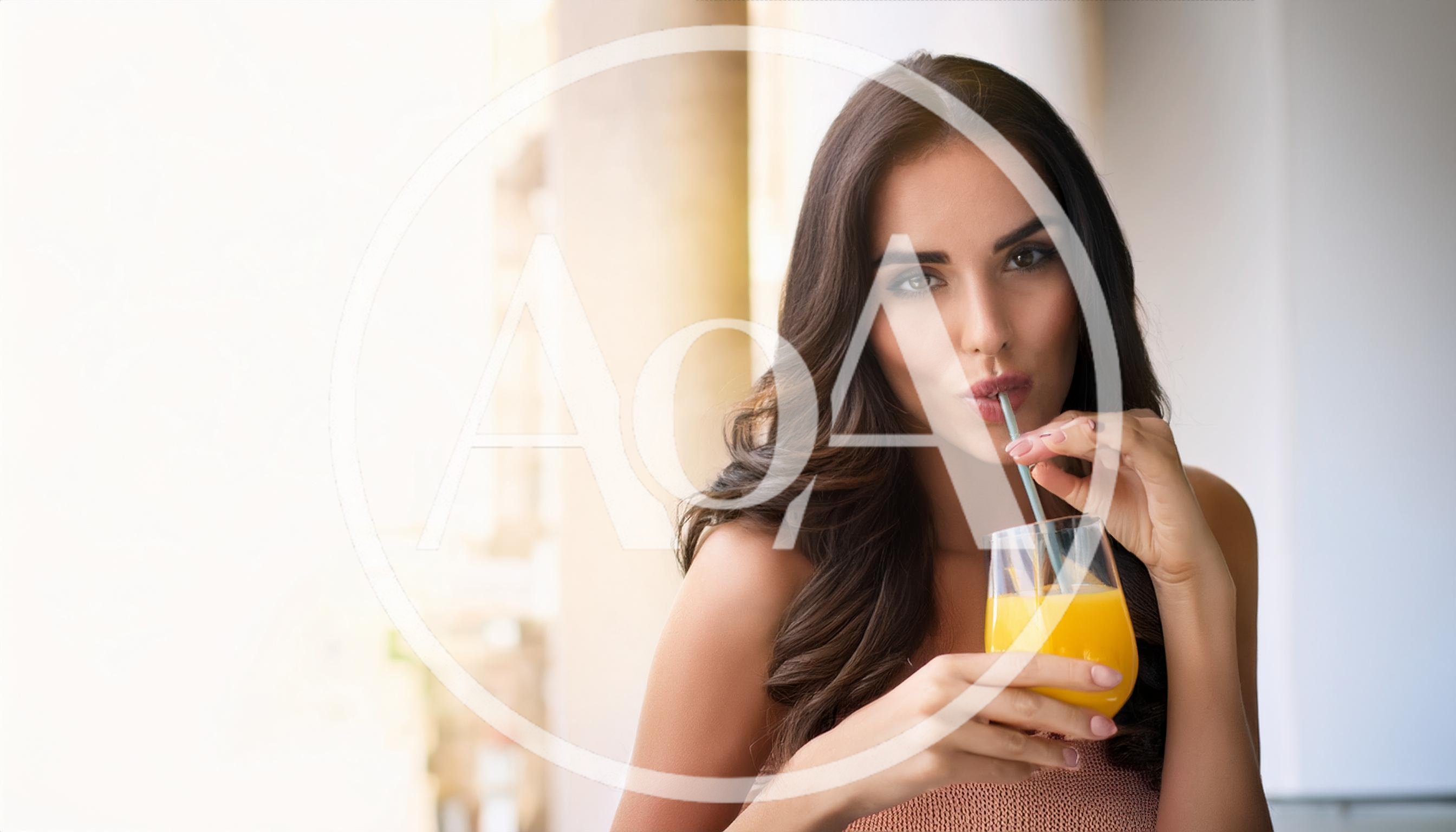 Beautiful Woman Drinking Orange Juice With A Straw