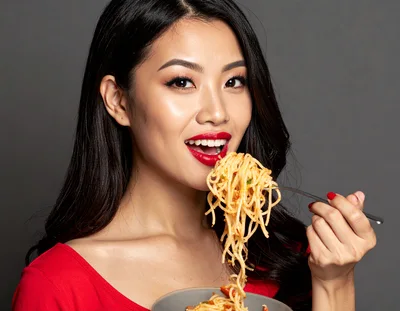 Young Asian Woman Eating Spaghetti With A Fork