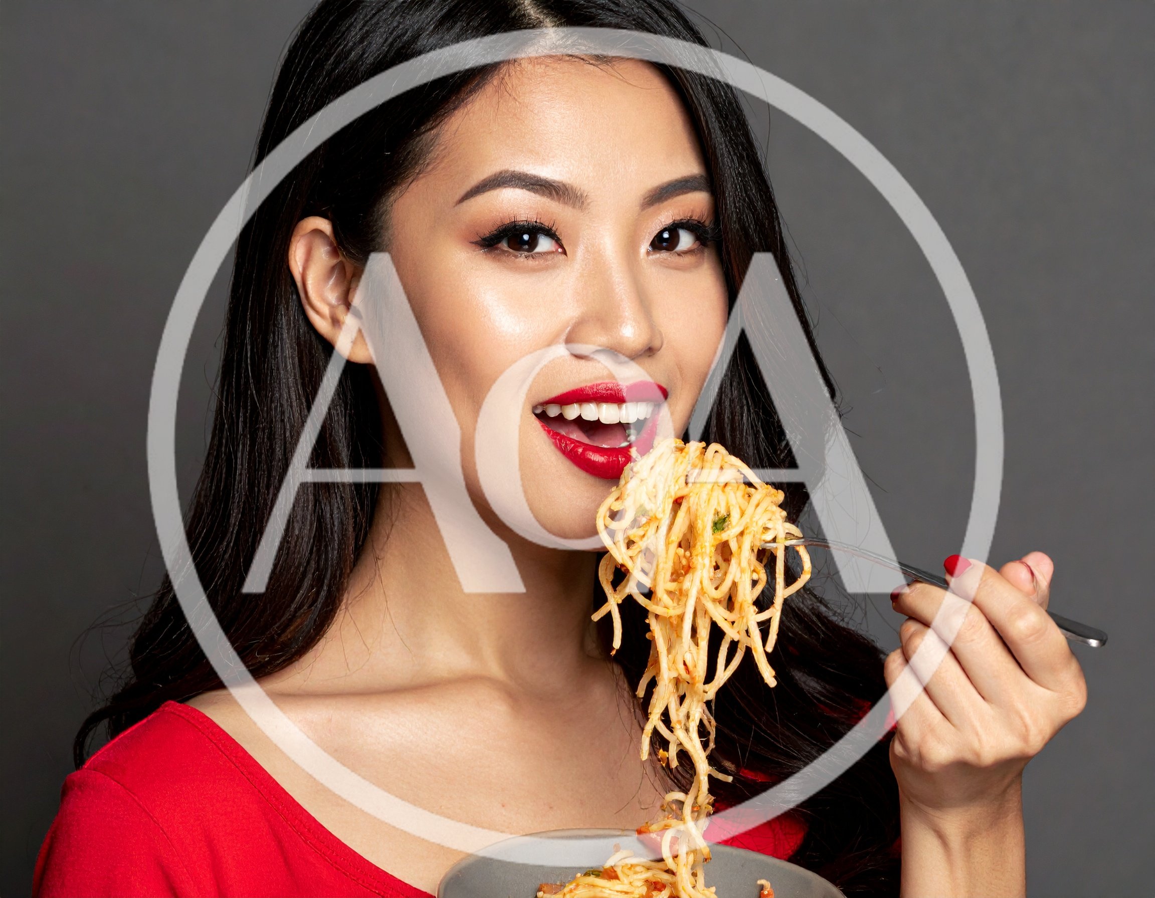 Young Asian Woman Eating Spaghetti With A Fork