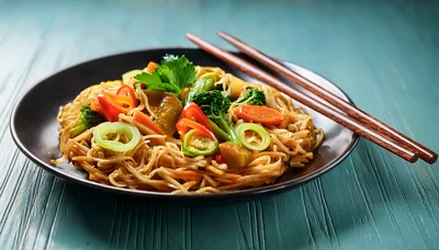 Stir Fried Noodles With Vegetables In A Black Bowl
