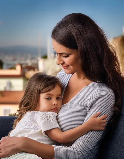 Mother Embracing Her Young Daughter Outdoors