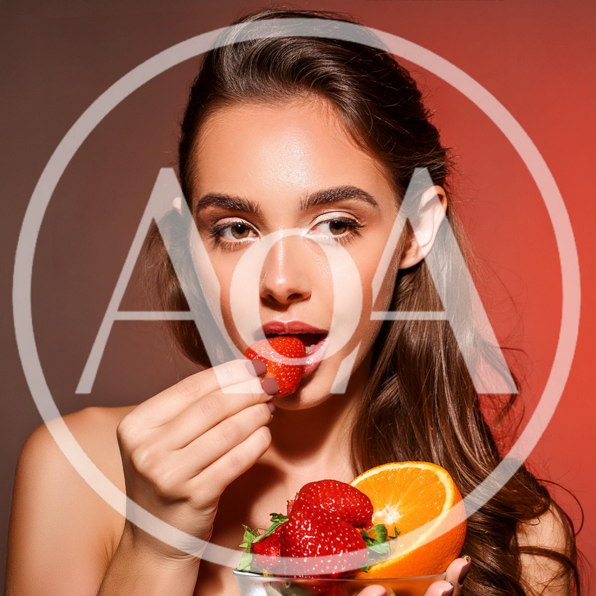 Beautiful Young Woman Eating Fresh Strawberry
