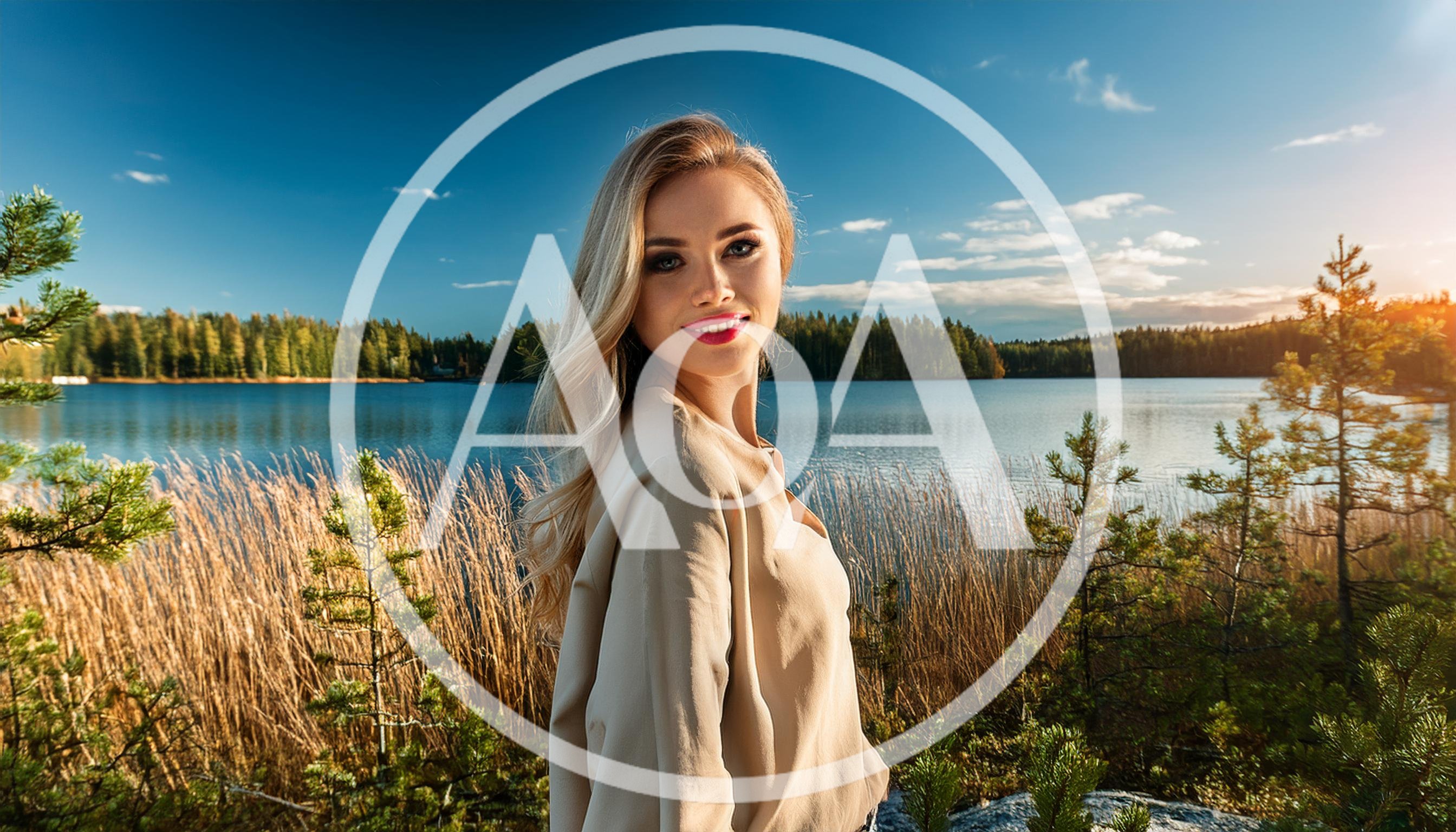 Beautiful Blonde Woman Posing By A Scenic Lake