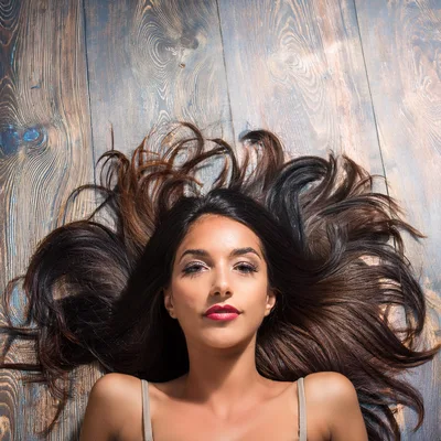 Beautiful Young Woman Lying On Wooden Floor