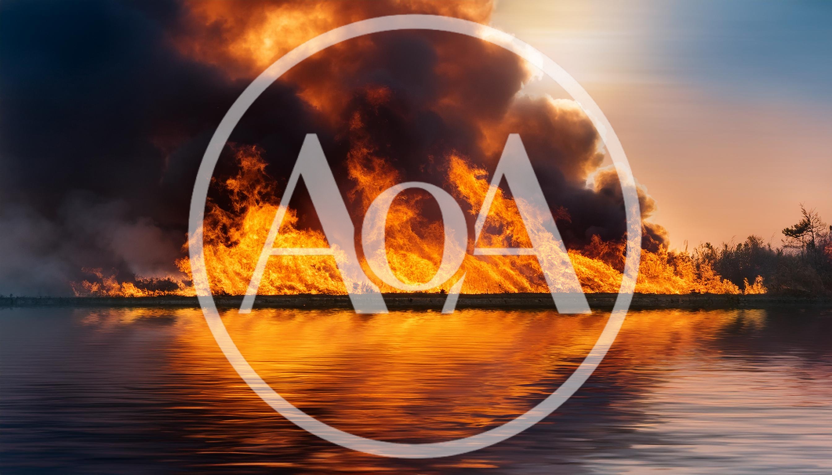 Intense Wildfire Burning Along A Calm Water Shoreline