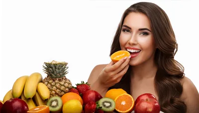 Beautiful Woman Eating Fresh Orange Slice With Fruit Assortment