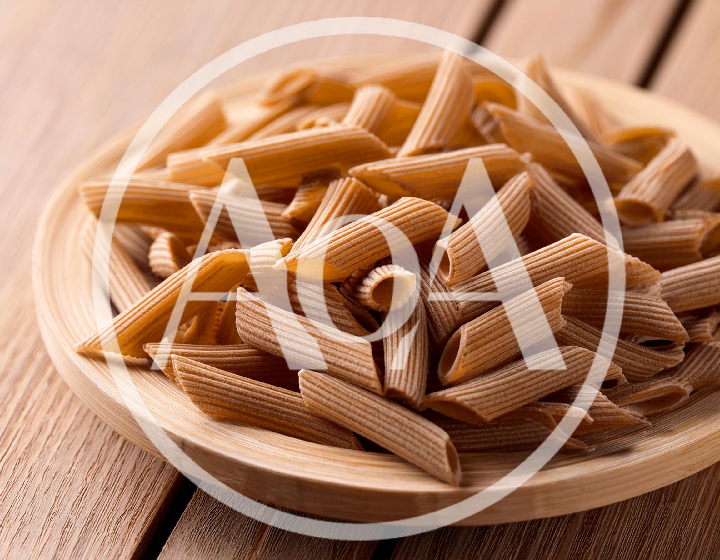Whole Wheat Penne Pasta On A Wooden Plate
