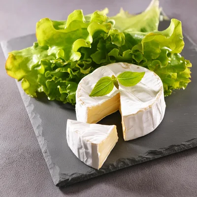 Camembert Cheese Wheel With Lettuce On Slate Board