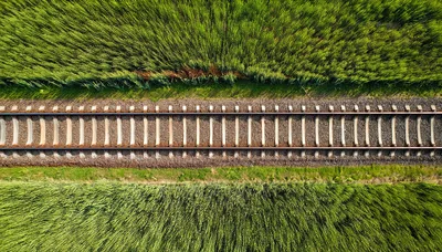 Aerial View Of Railway Tracks Through Green Fields