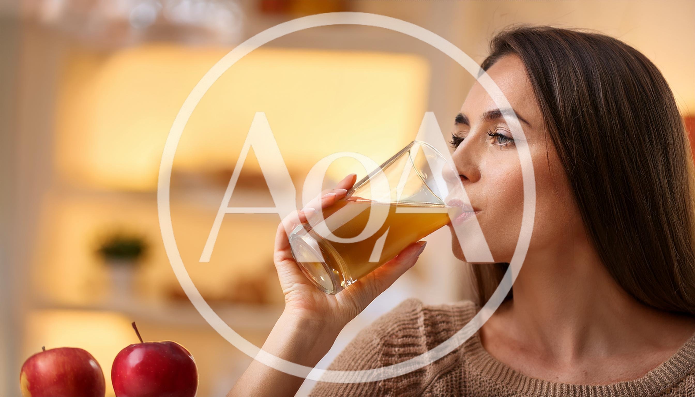 Young Woman Drinking Fresh Apple Juice At Home