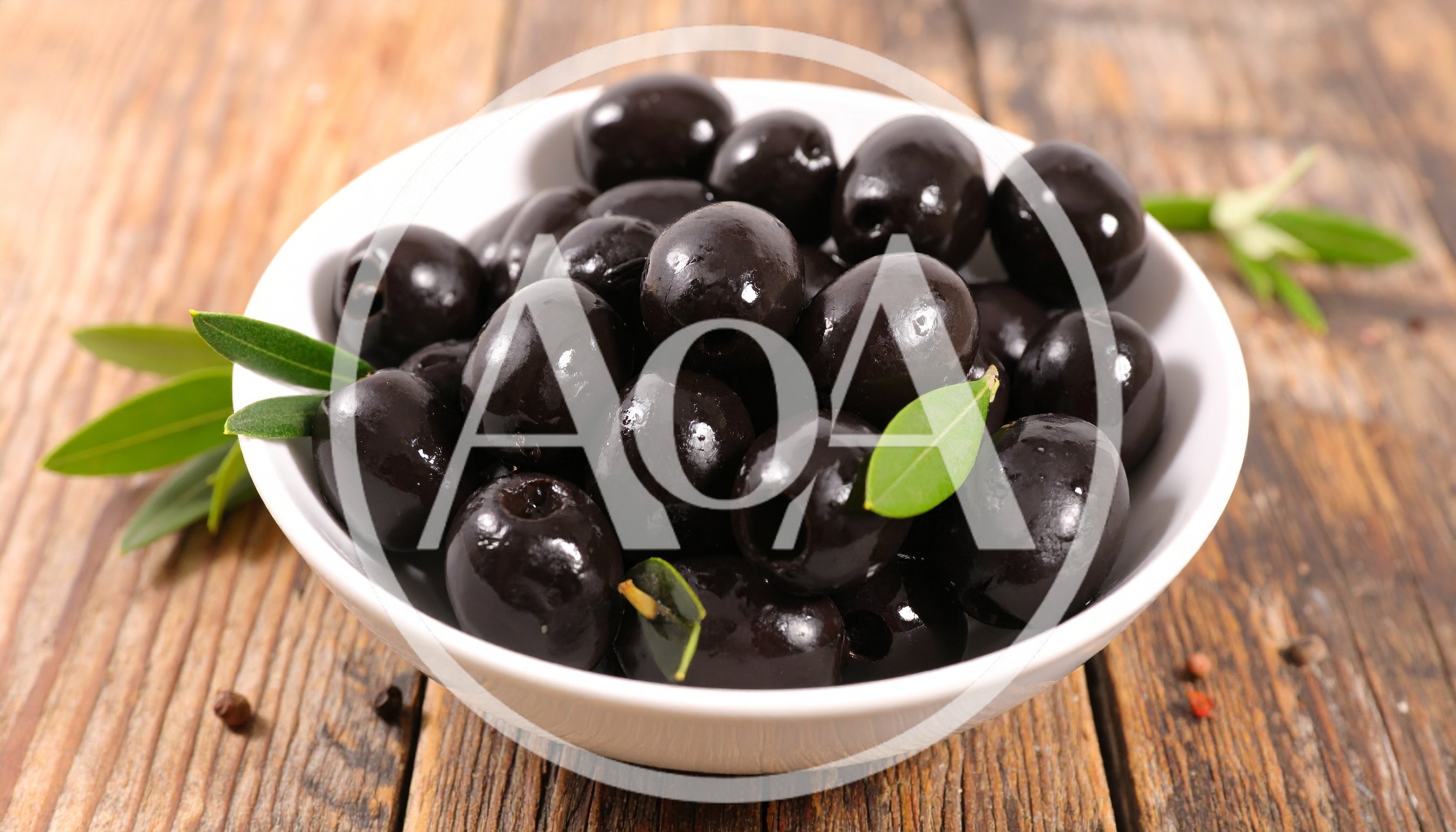 Bowl Of Pitted Black Olives On Wooden Table