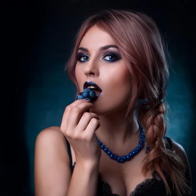 Woman With Blue Makeup Eating Fresh Blueberries