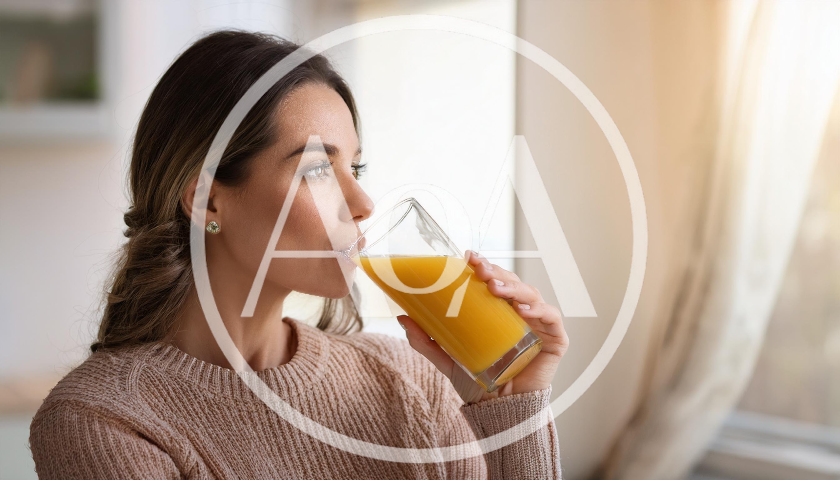 Young Woman Drinking Fresh Orange Juice At Home