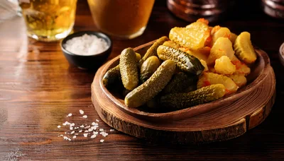 Pickles and Roasted Potatoes on a Wooden Platter