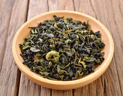 Dried Green Tea Leaves In A Wooden Bowl