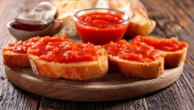 Toasted Bread Slices With Tomato Spread On Wooden Board