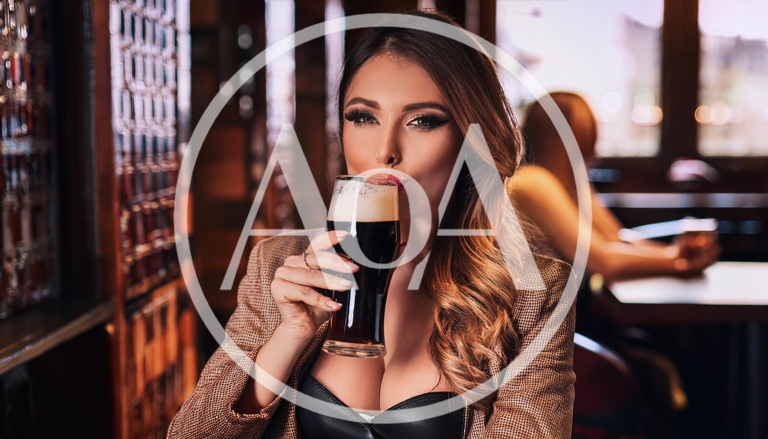 Beautiful Woman Drinking Dark Beer In A Pub