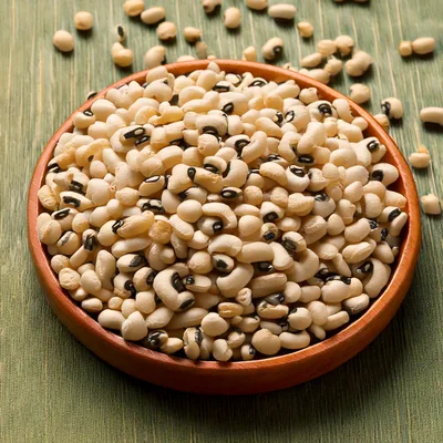 Bowl Of Raw Black Eyed Peas On Green Surface