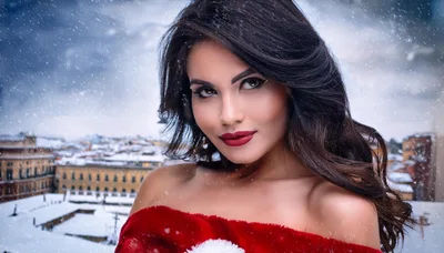 Beautiful Woman Wearing Santa Costume In Snowy Cityscape