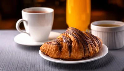 Chocolate Drizzled Croissant With Coffee And Orange Juice