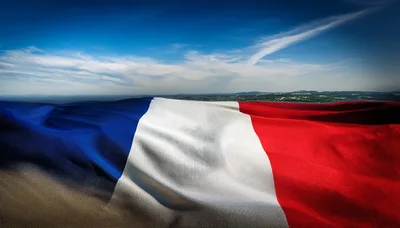 Waving French Flag Against A Scenic Landscape